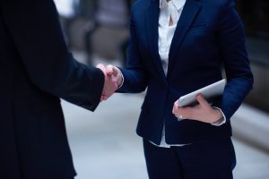 partnership concept with business man and woman hand shake and take agreement in modern office interior